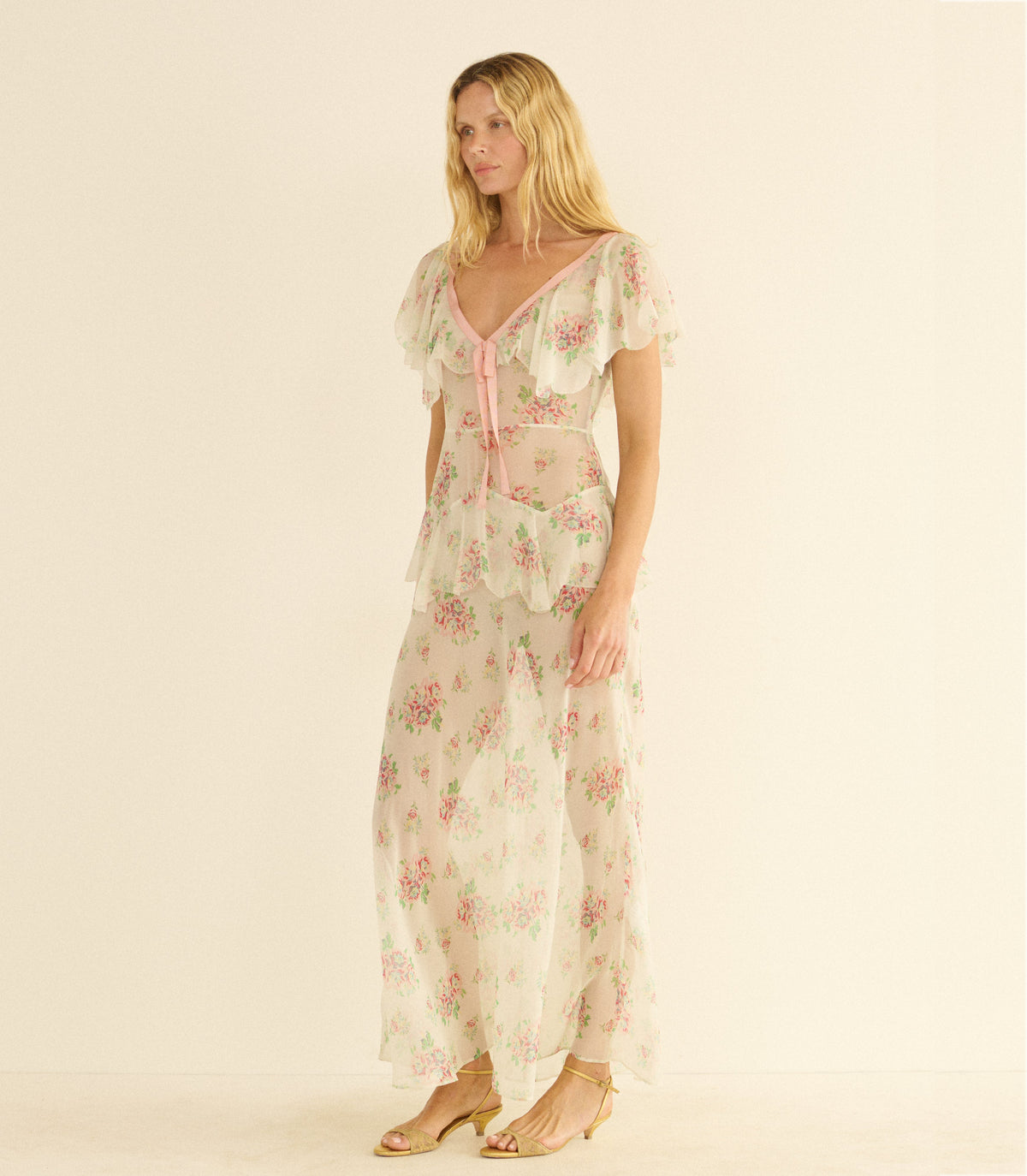 Woman wearing a white floral dress on a beige background